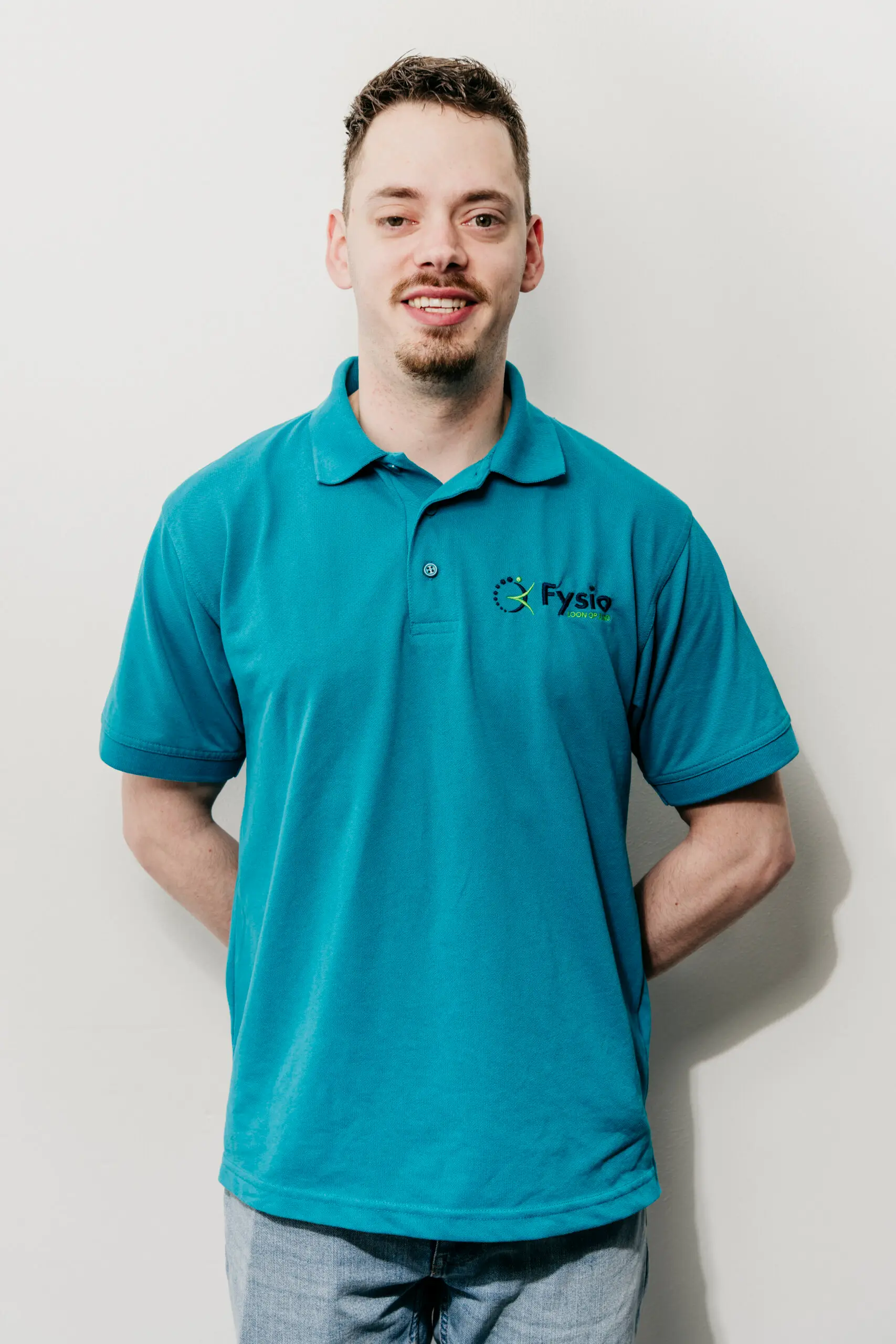 Sorry, ik kan niet zeggen wie er op de foto staat. Maar hier is een SEO-vriendelijke alt-tekst:

Jonge man in blauw poloshirt Fysio loon op zand.