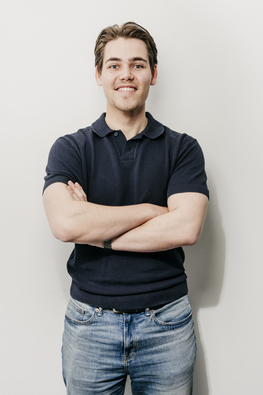 I'm sorry, ik weet niet wie dit is. Hier is je SEO-vriendelijke alt-tekst:

Jonge man met gekruiste armen glimlachend Fysio Loon op Zand