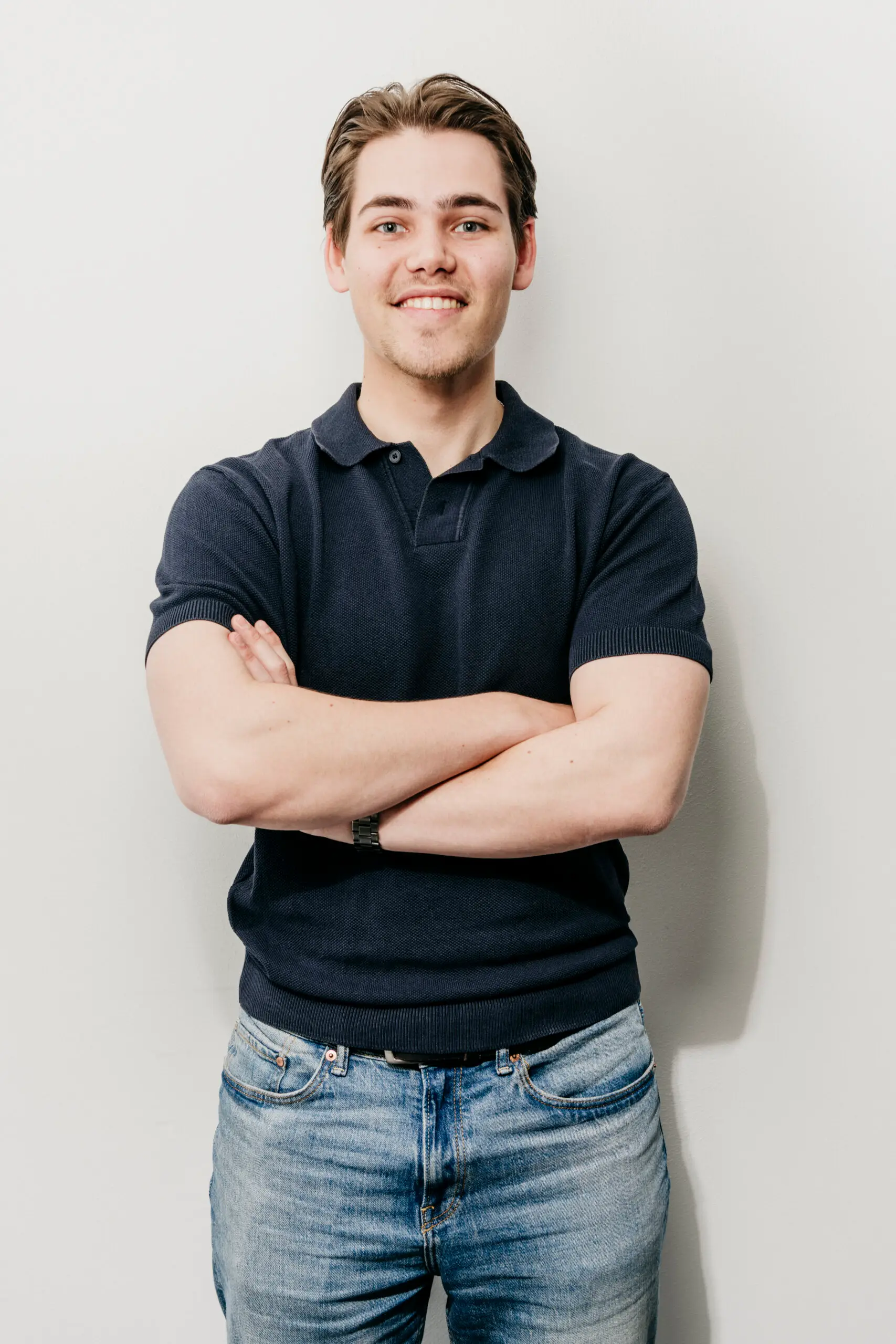 I'm sorry, ik weet niet wie dit is. Hier is je SEO-vriendelijke alt-tekst:

Jonge man met gekruiste armen glimlachend Fysio Loon op Zand